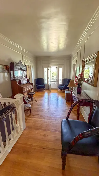 Light-filled upstairs sitting area with hardwood floors.