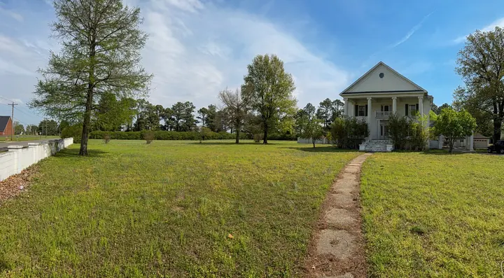 Wide lawn and approach toward the historic home.