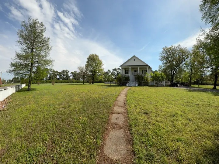 Long walkway through the lawn leading toward the home.
