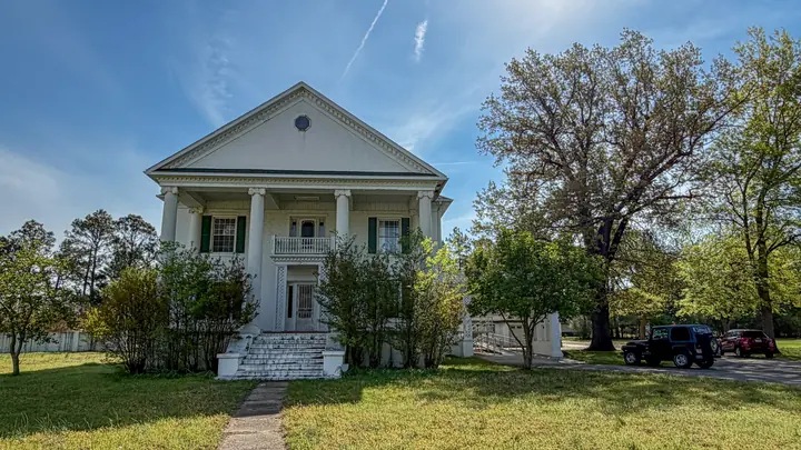 A classic front view with columns and a wide lawn.