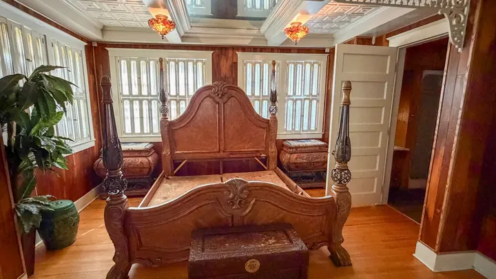 Bedroom with warm wood walls and historic detail.