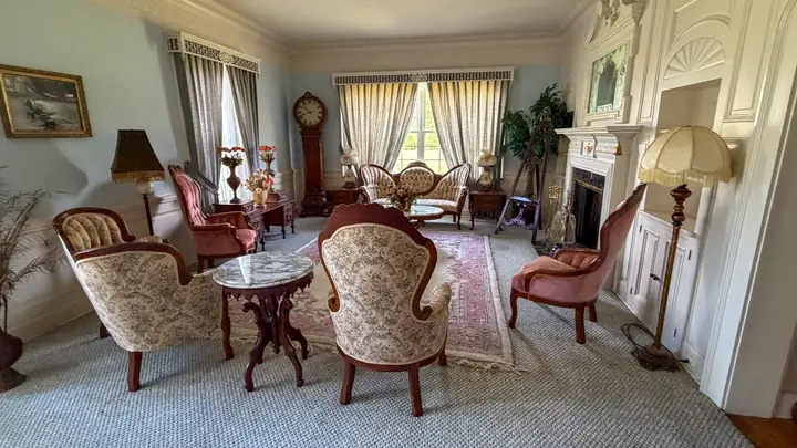 Interior sitting room with fireplace and traditional furnishings.