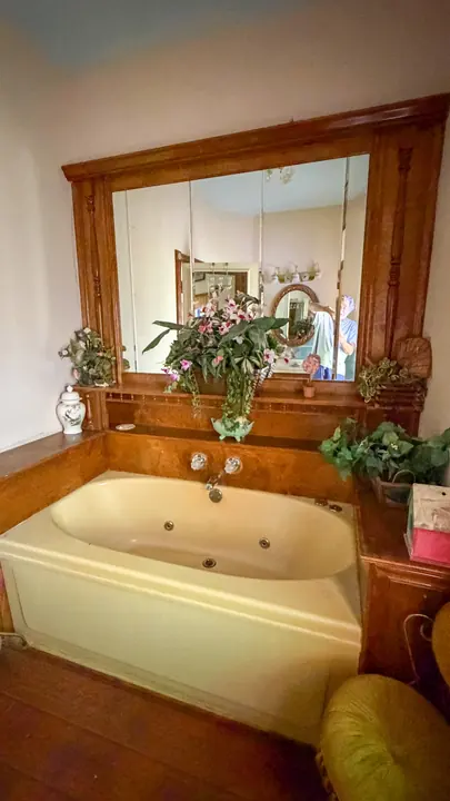 Bathroom with garden tub and mirrored wood surround.